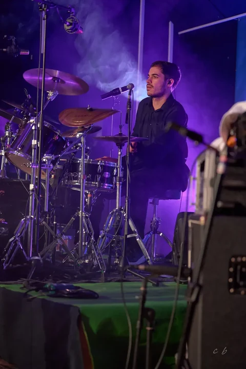 Batterie et musicien dans une ambiance lumineuse de concert