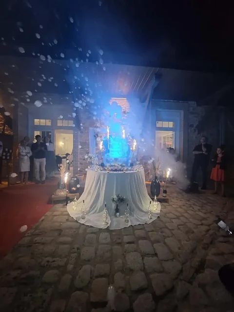 Table du gâteau de mariage éclairée en bleu, avec bulles et fontaines étincelantes