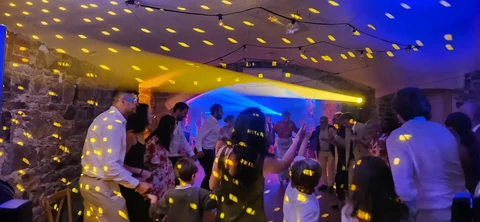 Invités dansant au Domaine de Keravel sous les faisceaux et motifs lumineux lors d’un mariage